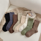 Checked knit crew socks in all colours, every colour laid out on a cozy blanket
