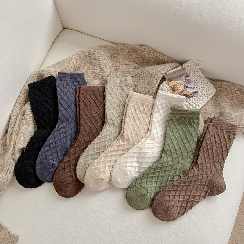Checked knit crew socks in all colours, every colour laid out on a cozy blanket