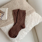 Coffee checked knit crew socks, on a fluffy blanket