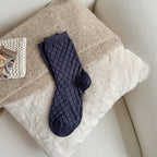 Navy blue checked knit crew socks, close-up on a fluffy blanket