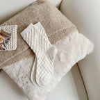White checked knit crew socks, on a fluffy blanket