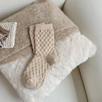 White checked knit crew socks, close-up on a fluffy blanket
