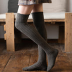Gray cotton thigh high socks, worn standing, side view of the ribbed knit