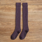 Purple cotton thigh high socks, flat lay on a wooden floor
