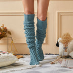 Blue fleece-lined knee high socks, slouched at the ankle in a cozy room