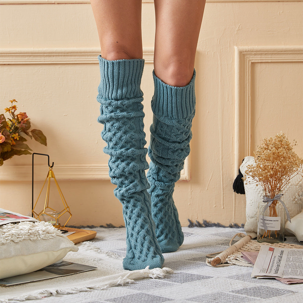 Blue fleece-lined knee high socks, slouched at the ankle in a cozy room