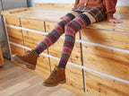 Fair Isle fuzzy thigh high leg warmers, worn sitting on a wooden ledge