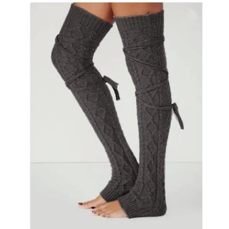 Dark gray long cable knit leg warmers, worn standing, side view