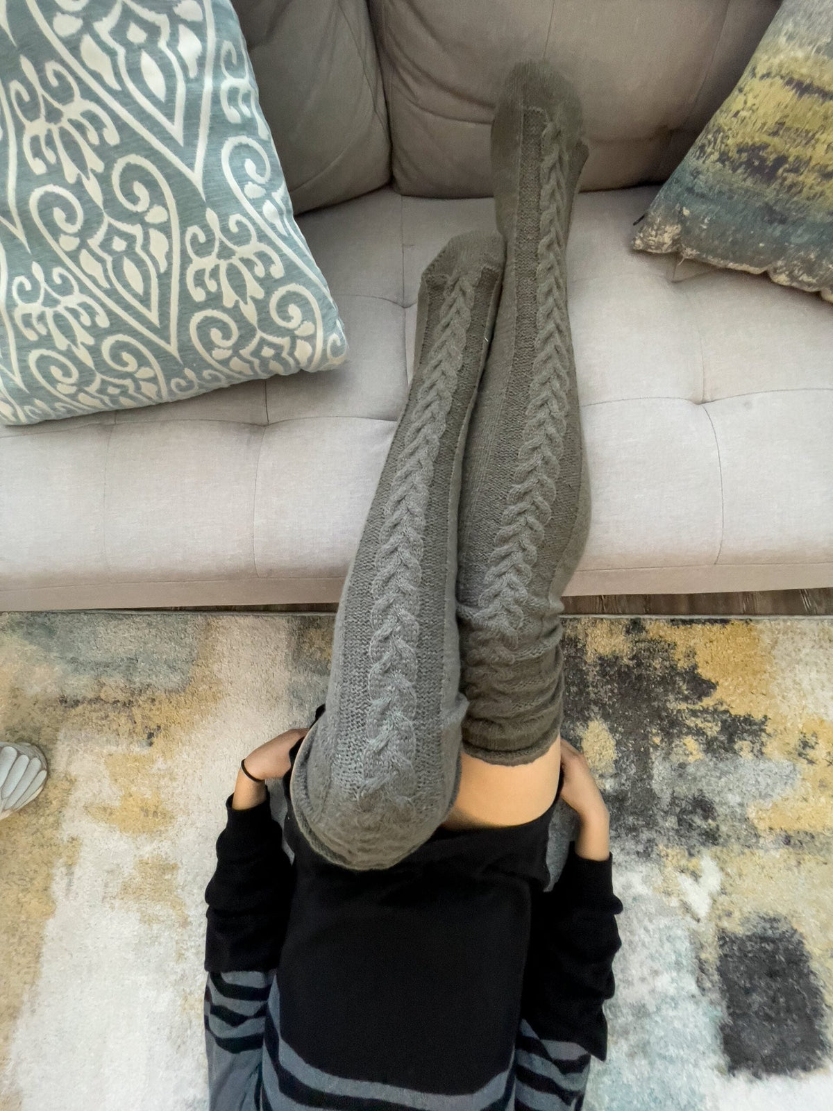 Gray long knit over the knee socks, legs raised on a sofa