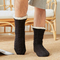 Black men's fleece-lined slipper socks, worn, close-up of the knit