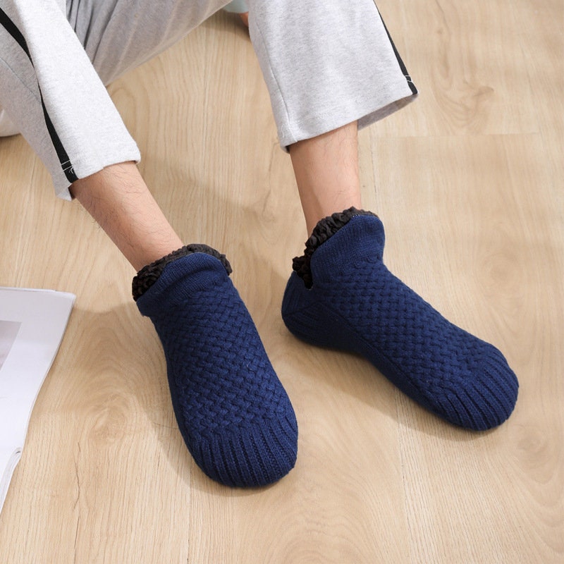 Navy blue non-slip slipper socks, worn walking on a wooden floor