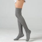 Light gray over the knee leg warmers, worn standing, side view of the cable knit