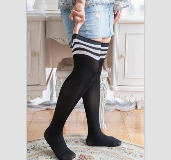 Black plus size over the knee socks with white stripes, worn with a denim skirt