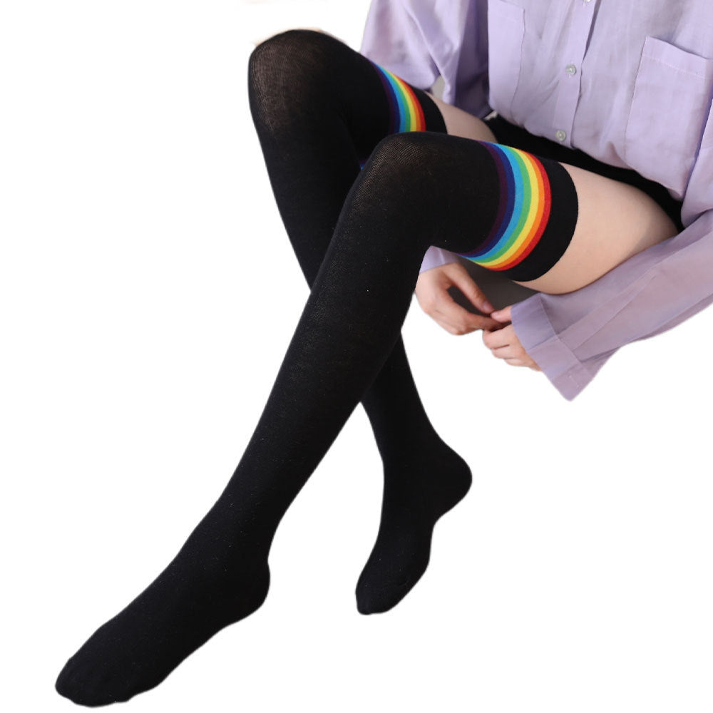 Black rainbow stripe thigh high socks, worn sitting, side view