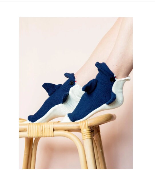 Blue shark slipper socks, worn with feet up on a stool