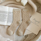 Khaki soft knit crew socks, pair laid on an open book