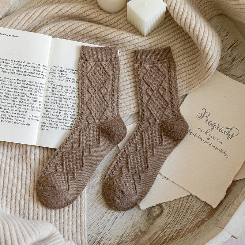 Light coffee soft knit crew socks, pair laid on an open book